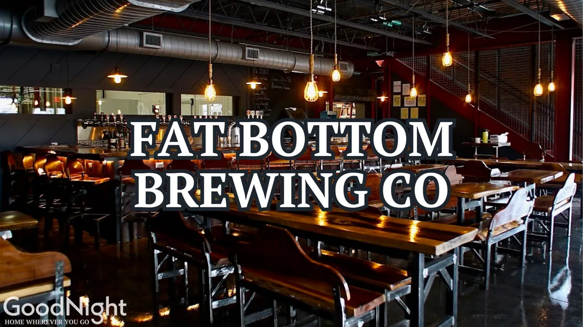 The lively interior of a brewery or taproom, with long wooden tables, a bustling bar area, and hanging pendant lights. People are shown socializing, sampling craft beers, and possibly enjoying live music—offering a sense of camaraderie and fun.