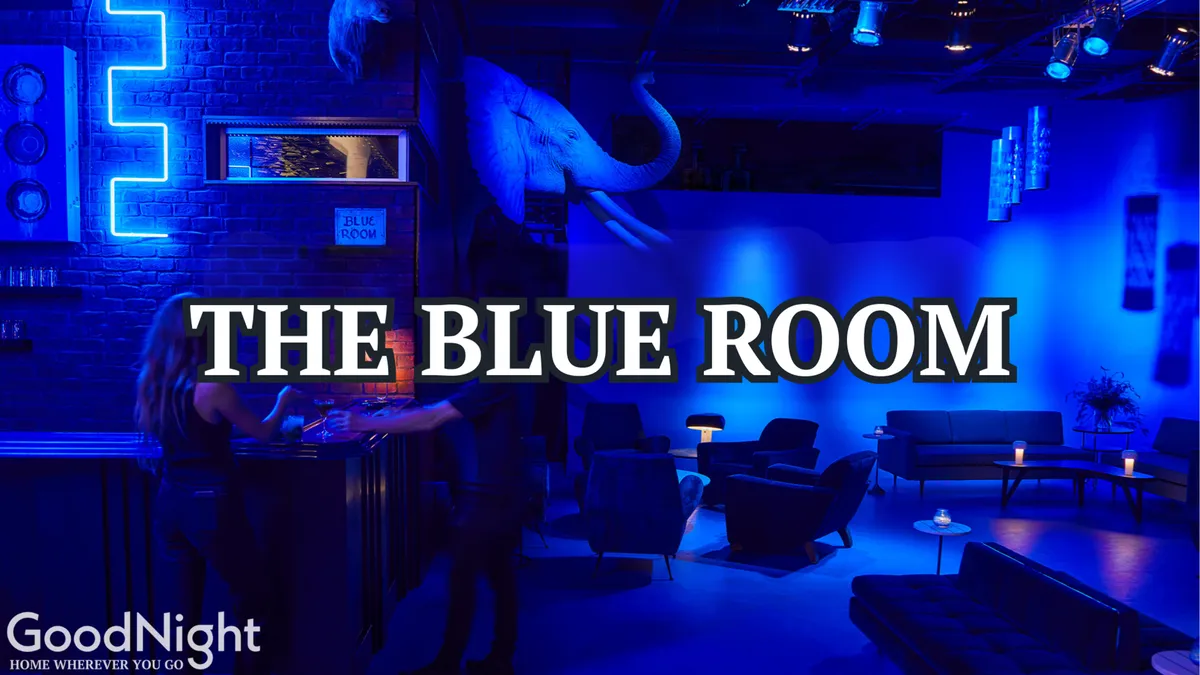 A chic and modern bar interior, aglow with blue lighting, featuring unique elephant head decor, a stylish bar area, and inviting seating. The ambiance encourages intimate conversations and celebratory toasts, evoking the upscale side of Nashville’s nightlife.