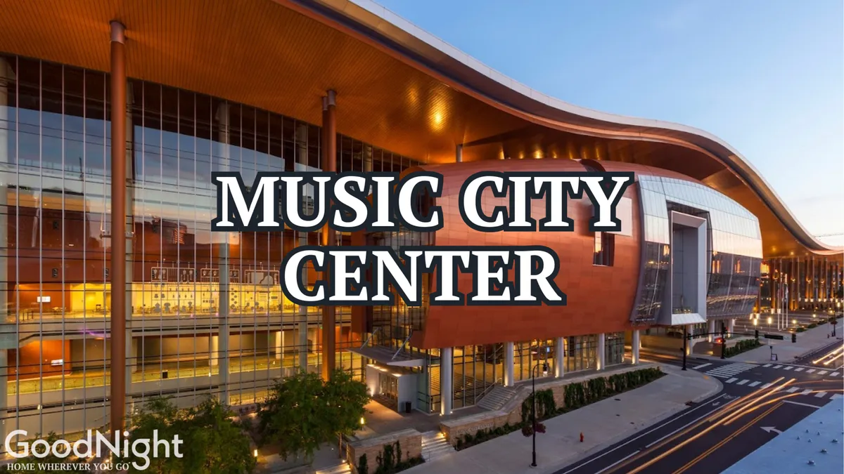 A striking view of a modern architectural venue with expansive glass windows and a distinctive curved roof, hinting at energetic cultural or business events inside.